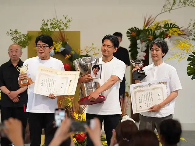 中山佳巳氏の写真を持つ原さん